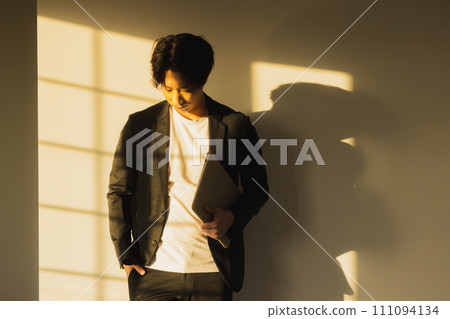 Man by the window in the evening 111094134