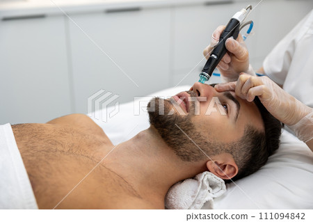 Man having cosmetological procedures in a beauty clinic Man having cosmetological procedures in a beauty clinic 111094842