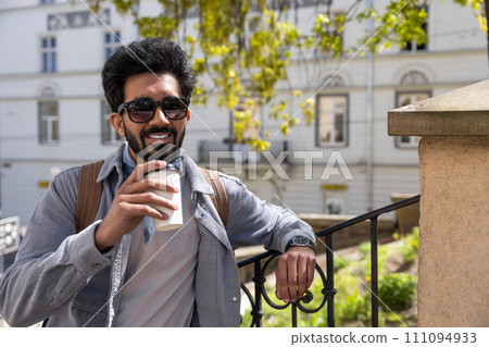 Smiling positive hindu man with a cup of coffee in hands 111094933