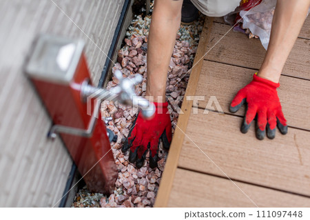 A man laying gravel in the garden, gardening A man laying gravel in the garden, gardening 111097448