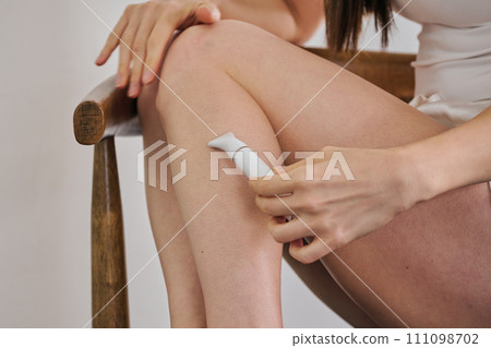 一名30多歲的女士用電動刮鬍刀剃頭髮 一名30多歲的女士用電動刮鬍刀剃頭髮 111098702