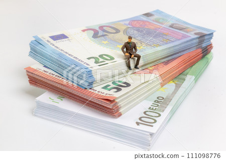 Miniature businessman navigates the financial landscape, surrounded by Euro banknotes, Miniature businessman navigates the financial landscape, surrounded by Euro banknotes, 111098776