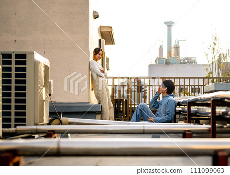 man and woman talking on the rooftop 111099063