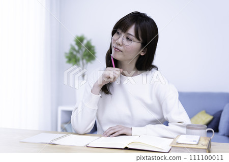 一位戴眼鏡的女士在明亮的客廳裡學習 111100011