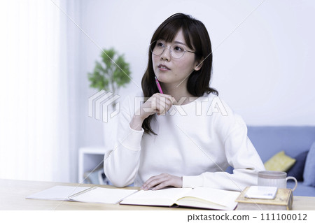一位戴眼鏡的女士在明亮的客廳裡學習 111100012