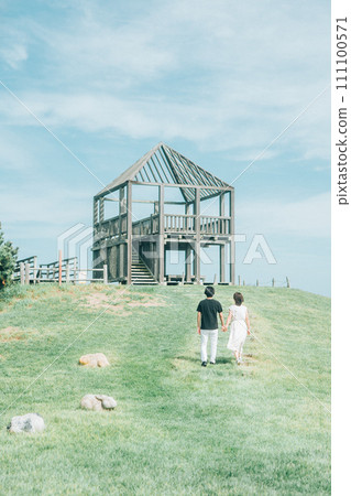 一個男人和一個女人手牽手爬公園裡的小山 111100571