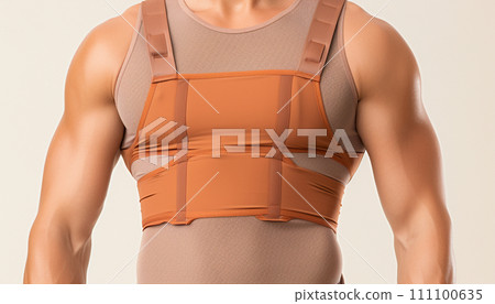 Upper body of an athletic man with a posture support brace in orange over a gray shirt 111100635
