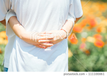 Hands hugging in a flower garden Hands hugging in a flower garden 111100861