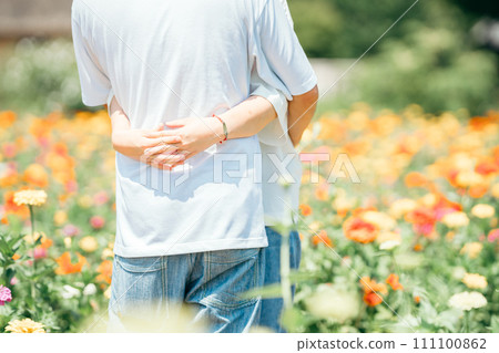 Hands hugging in a flower garden 111100862