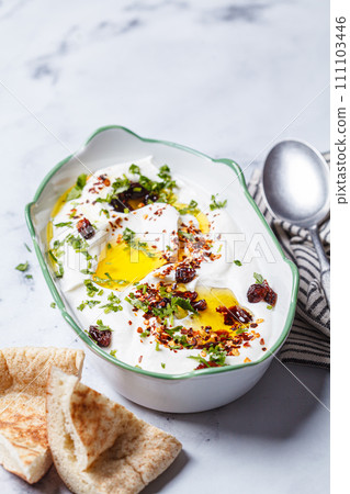 Whipped feta dip with chili, oil and cilantro. 111103446