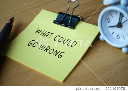 What could go wrong text on sticky note with alarm clock background 111103978