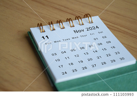 Close up side view of November 2024 calendar on wooden desk. Calendar concept Close up side view of November 2024 calendar on wooden desk. Calendar concept 111103993