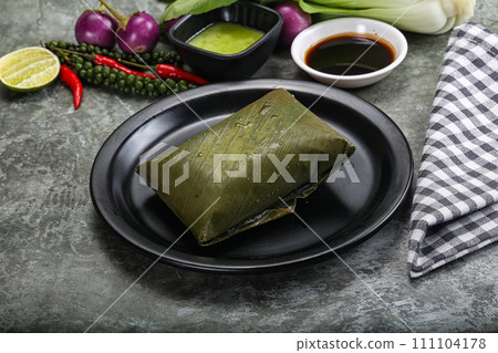 Asian cuisine - rice with filling in banana leaf Asian cuisine - rice with filling in banana leaf 111104178