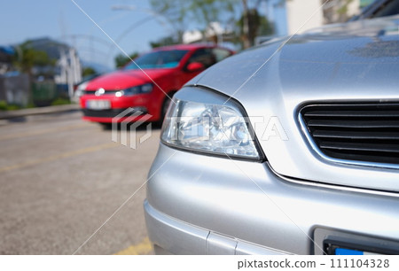 Closeup of clean headlights of silvery car in parking 111104328