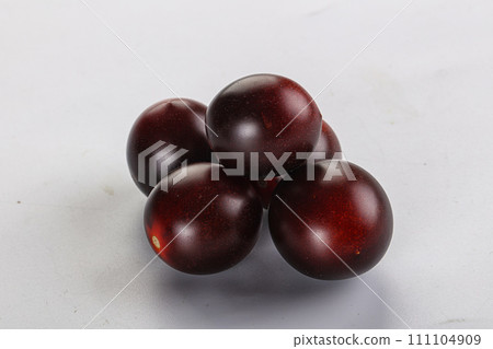 Raw ripe black kumato tomato Raw ripe black kumato tomato 111104909
