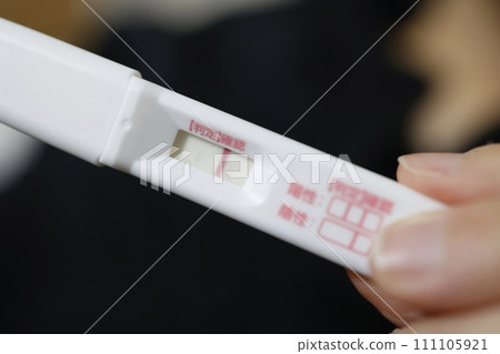 A commercially available pregnancy test with a faint positive line 111105921