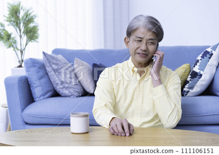 中年男子在客廳用智慧型手機交談 中年男子在客廳用智慧型手機交談 111106151