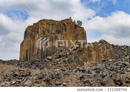 Geologic basalt rock formation. Basalt quarry. Columnar basalt quarry in summer. 111109744