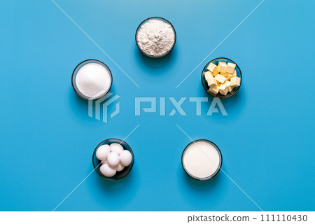 Sweets baking ingredients top view, isolated on a blue background Sweets baking ingredients top view, isolated on a blue background 111110430