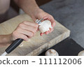 The process of peeling mushrooms. A woman's hands peel mushrooms with a knife, close-up. Cooking mushrooms. 111112006