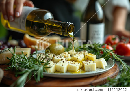 Close-up of woman pouring olive oil over sheep cheese on plate. 111112022