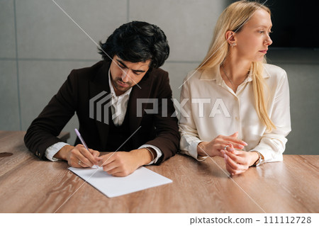 Portrait of sad spouses couple signing decree papers getting divorced in lawyers office at desk. Unhappy married family split break up end relationships giving permission to marriage dissolution. Portrait of sad spouses couple signing decree papers getting divorced in lawyers office at desk. Unhappy married family split break up end relationships giving permission to marriage dissolution. 111112728