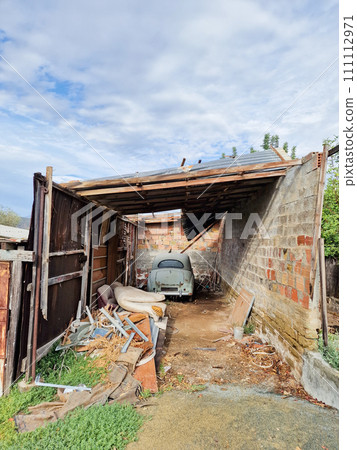 Rusty old vintage car in an abandoned garage Rusty old vintage car in an abandoned garage 111112971