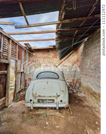 Rusty old vintage car in an abandoned garage Rusty old vintage car in an abandoned garage 111112972