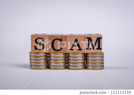 The inscription Scam made of wooden cubes on a plain background The inscription Scam made of wooden cubes on a plain background 111113170