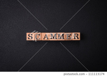 The inscription Scammer made of wooden cubes on a plain background 111113174