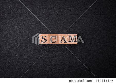 The inscription Scam made of wooden cubes on a plain background 111113176