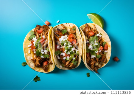 Top view of mexican pork carnitas tacos with greens and tomato on the blue background Top view of mexican pork carnitas tacos with greens and tomato on the blue background 111113826