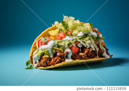 Juicy beef taco topped with sour cream and veggies on the blue background Juicy beef taco topped with sour cream and veggies on the blue background 111113839