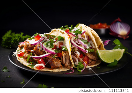 Mexican pork carnitas tacos with greens, tomato and veggies on a black plate 111113841