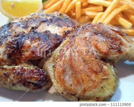 dish with half a grilled chicken and french fries dish with half a grilled chicken and french fries 111113908