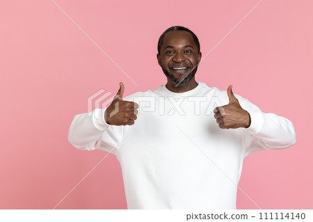 Positive black man wearing white sweatshirt showing thumbs up 111114140