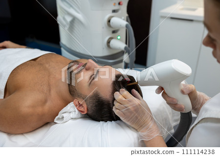 Customer in a beauty clinic having anti hair loss procedures Customer in a beauty clinic having anti hair loss procedures 111114238