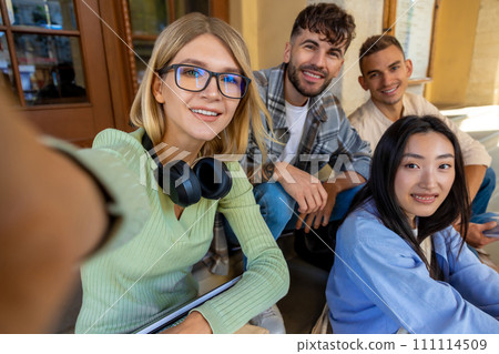 Students making selfie together while sitting on stairs in university campus. Students making selfie together while sitting on stairs in university campus. 111114509