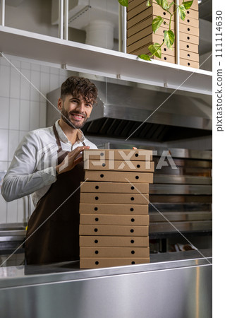 Male service man with many pizza boxes in pizzeria Male service man with many pizza boxes in pizzeria 111114630