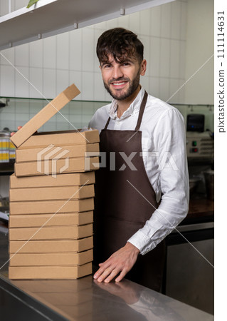 Male service man with many pizza boxes in pizzeria Male service man with many pizza boxes in pizzeria 111114631
