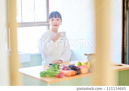 A young woman relaxing in the kitchen A young woman relaxing in the kitchen 111114685