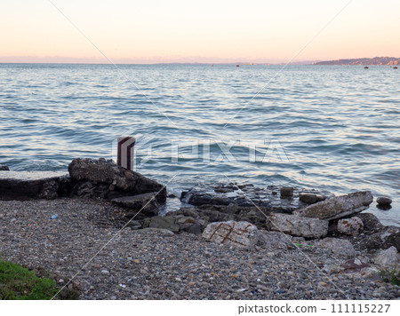 The atmosphere of a cargo seaport. Marine urban landscape. Old rusty bollard and concrete pier The atmosphere of a cargo seaport. Marine urban landscape. Old rusty bollard and concrete pier 111115227