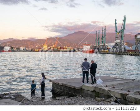 Port area. Container ships in the port. The atmosphere of a cargo seaport. Marine urban landscape. Shipping in Georgia. People on the concrete pier. Port area. Container ships in the port. The atmosphere of a cargo seaport. Marine urban landscape. Shipping in Georgia. People on the concrete pier. 111115228