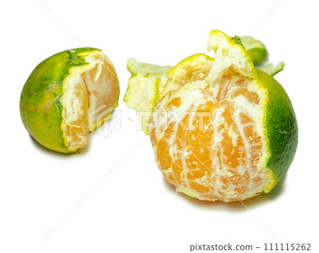 Unripe tangerine. Peeling a tangerine. Green fruit on a white background. Sour ingredient. Citrus isolate. 111115262