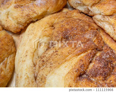 Wicker bun with cinnamon and sugar. Bread product of an unusual shape. Homemade baking. Buns with a ruddy crust. Wicker bun with cinnamon and sugar. Bread product of an unusual shape. Homemade baking. Buns with a ruddy crust. 111115908