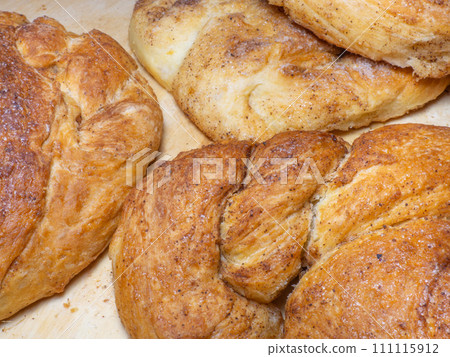 Wicker bun with cinnamon and sugar. Bread product of an unusual shape. Homemade baking. Buns with a ruddy crust. Wicker bun with cinnamon and sugar. Bread product of an unusual shape. Homemade baking. Buns with a ruddy crust. 111115912
