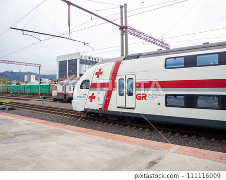 At the pier near the departing train. Train locomotive. Georgian railways.   Passenger train at the station. Passenger transportation 111116009
