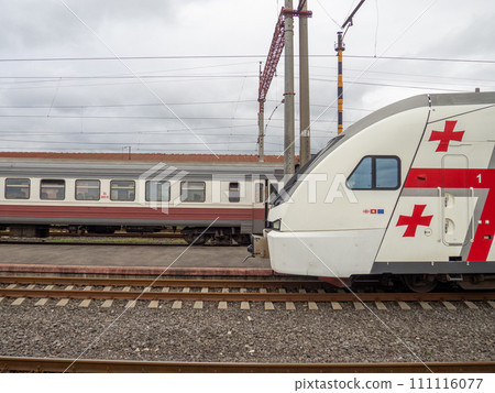 Passenger train at the station. Passenger transportation. At the pier near the departing train. Train locomotive. 111116077