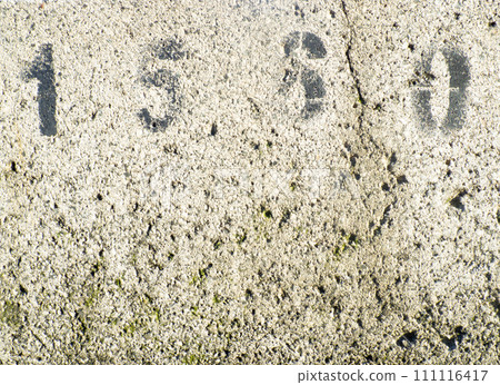 Background of porous concrete. Numbers on concrete. Gray wall. Solid background. 111116417