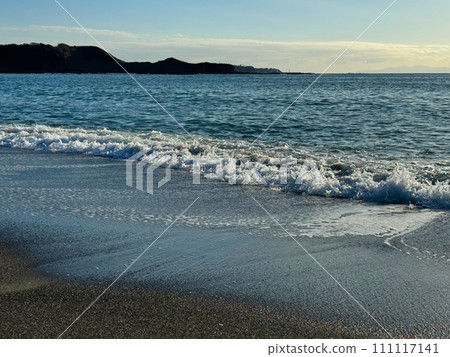 A photo looking down from a hill, with the waves crashing on the big ocean, the blue sky, the sun, and the setting sun mixing together. A photo looking down from a hill, with the waves crashing on the big ocean, the blue sky, the sun, and the setting sun mixing together. 111117141